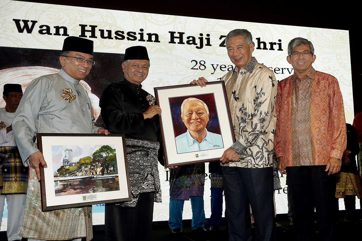LBKM immediate past president Wan Hussin Zoohri (second from left) receiving a portrait of himself from PM Lee in recognition of his services. With them are current president Suhaimi (far left) andDr Yaacob.