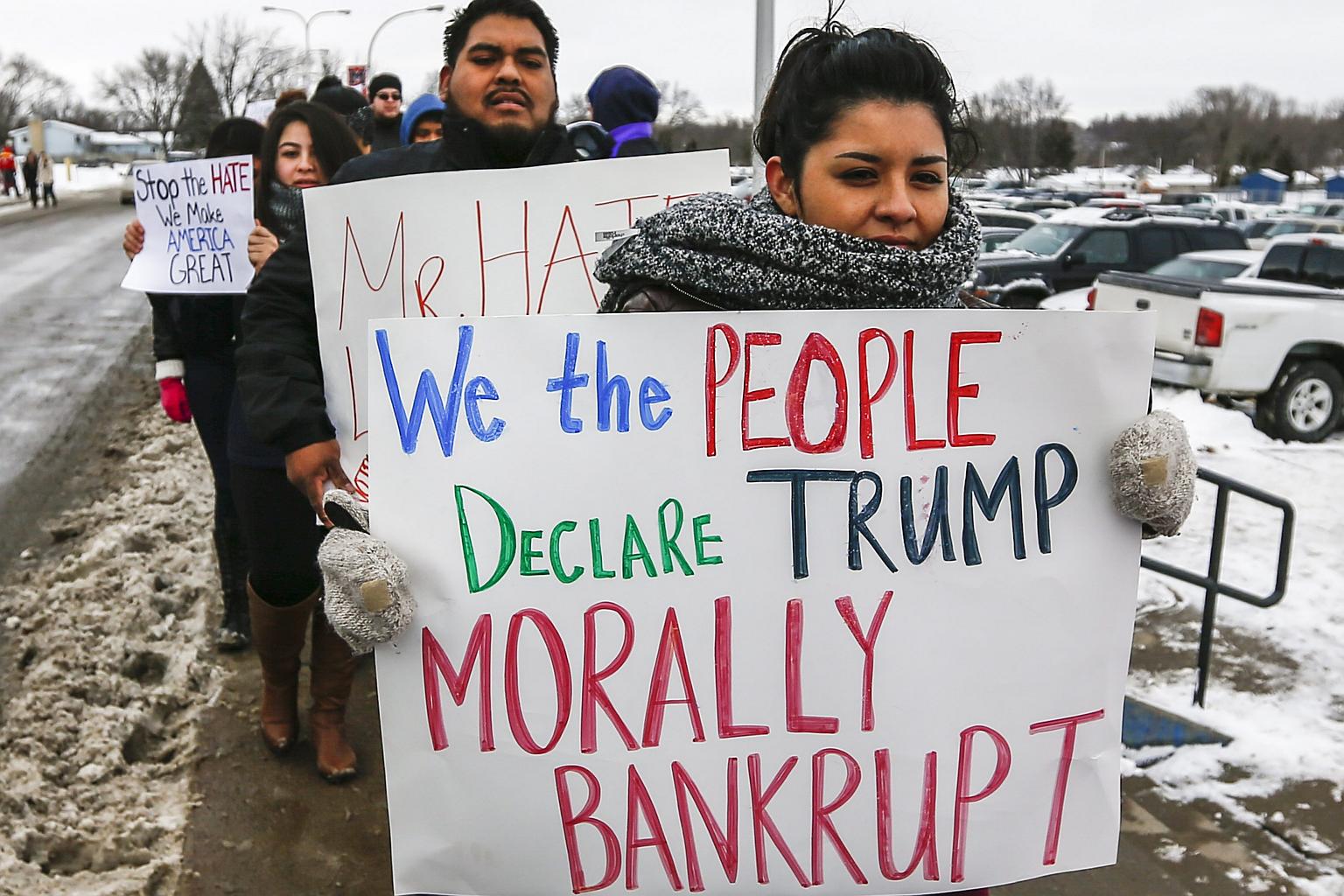 Protesters against Republican presidential candidate Donald Trump's stance on immigration picket his campaign event at Marshalltown Community School District Roundhouse Gym.