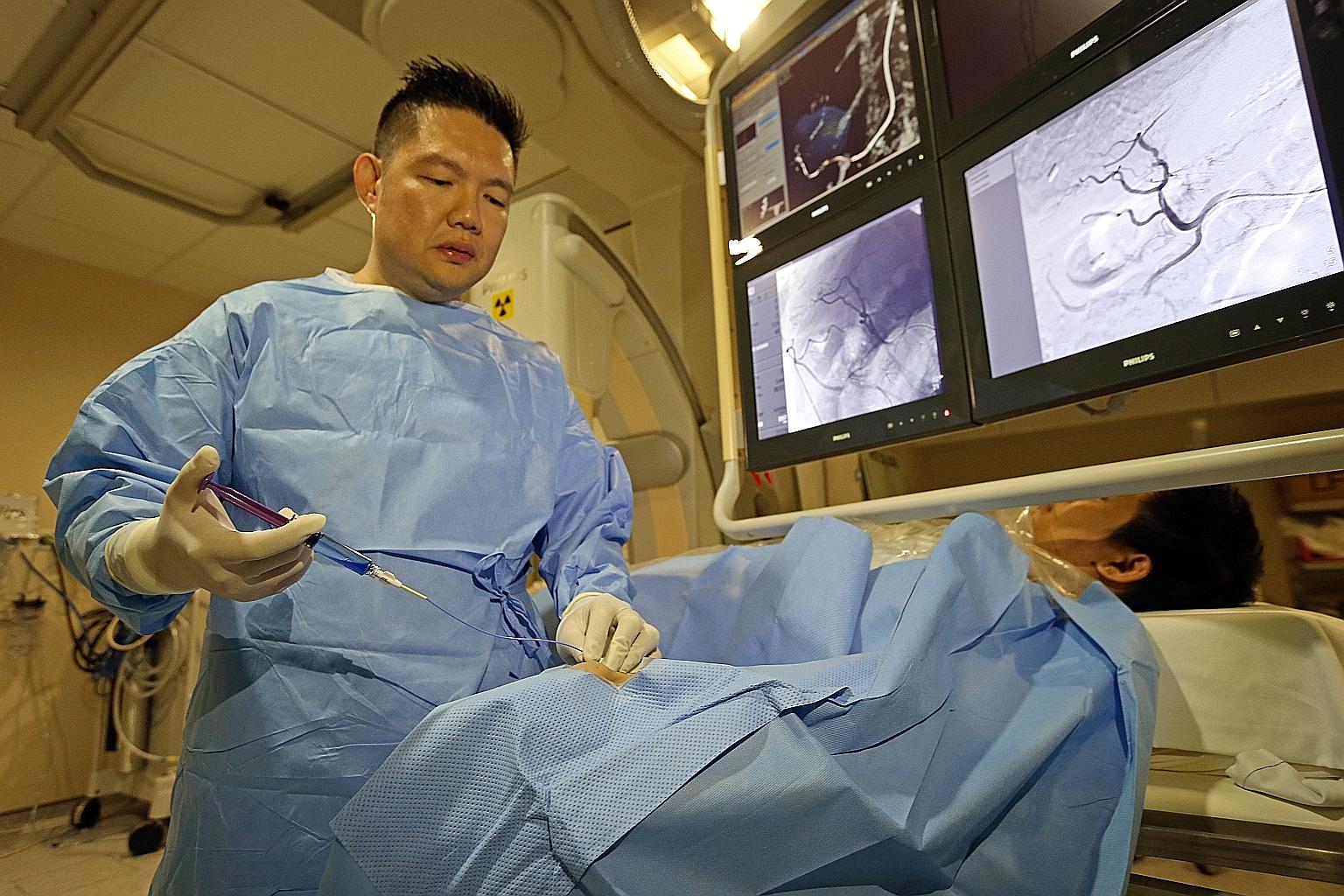 Professor Pua shows how the new technique to treat liver cancer works in a mock procedure. A catheter is inserted through the radial artery in the wrist instead of the femoral artery in the groin.