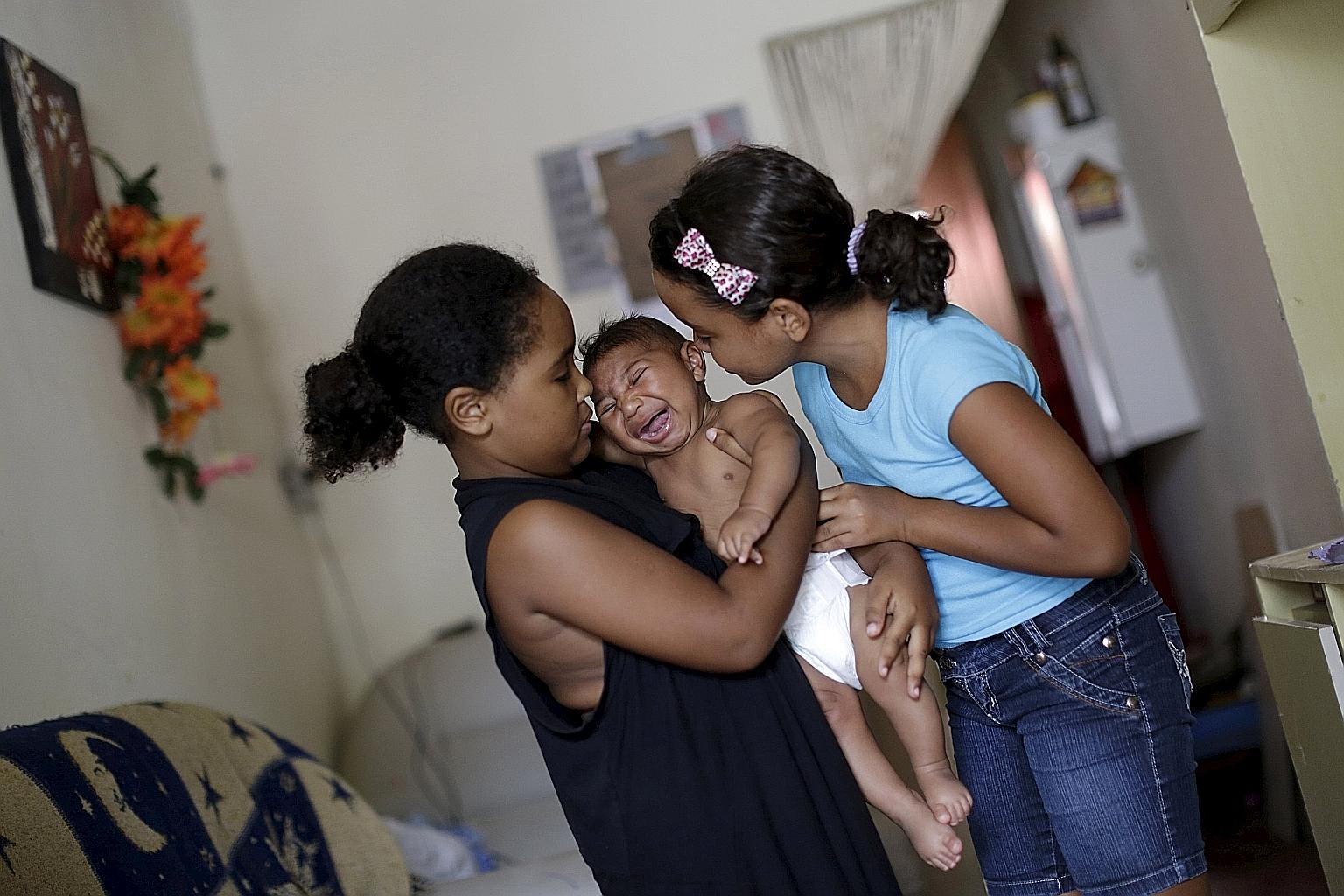 Two Brazilian girls in Recife city with their brother, who has microcephaly, a neurological disorder associated with the Zika virus.