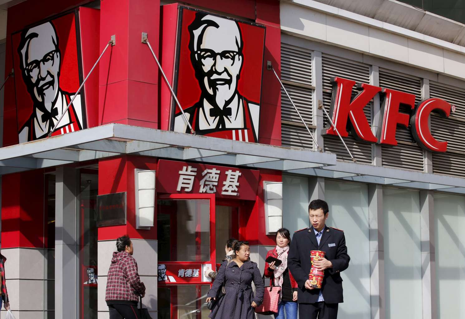 A man holds instant noodle packs in front of a KFC restaurant in Beijing.