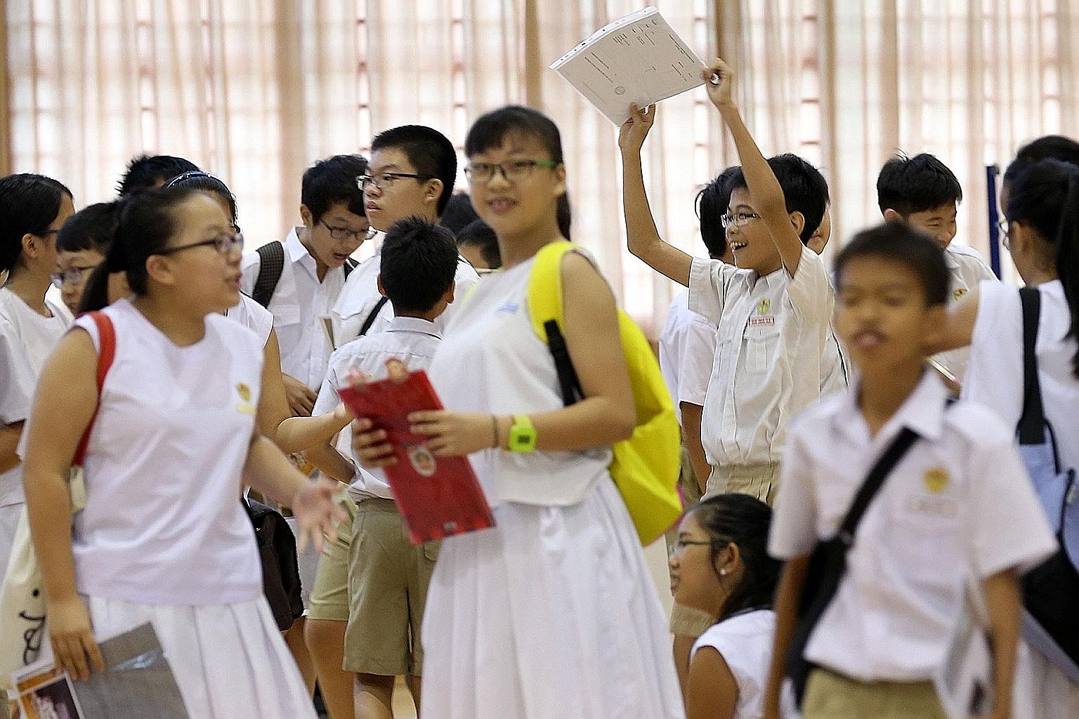 Pupils with their PSLE results. The MOE's stance on strictly adhering to cut-off points seems to go against the new direction of learning.