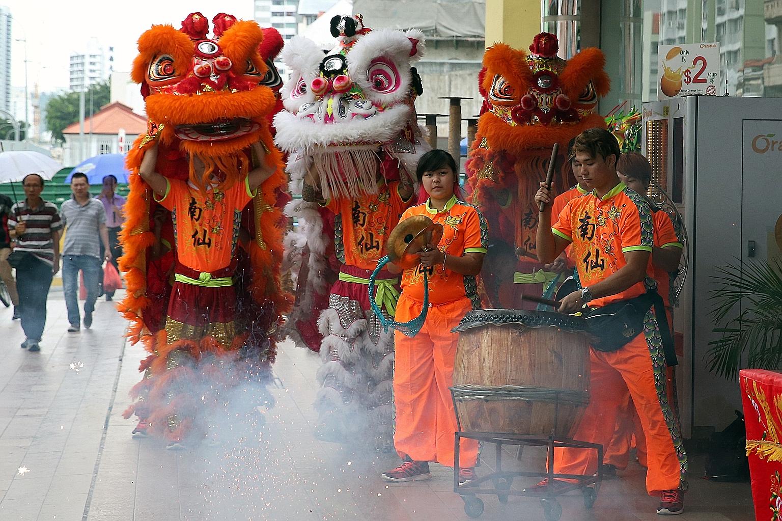 The Nam Sieng Dragon and Lion Dance troupe performing at Sim Lim Tower yesterday. Many of the acrobatic stunts require considerable strength, speed and agility, so young performers are vital to preserving the vigour and traditions of the lion dance.