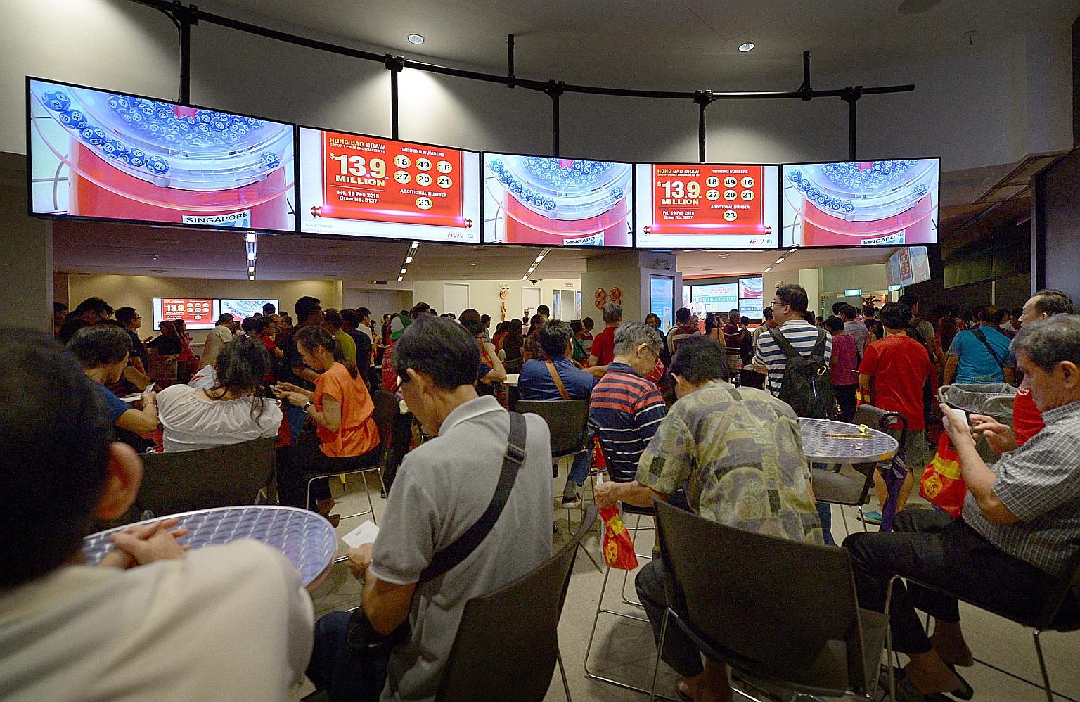 The crowd at the Singapore Pools main branch in Middle Road after the results for the Toto Hongbao Draw were announced last night. The $13.9 million prize will be shared between two winners, who bought their winning tickets in Marina Bay Sands mall a