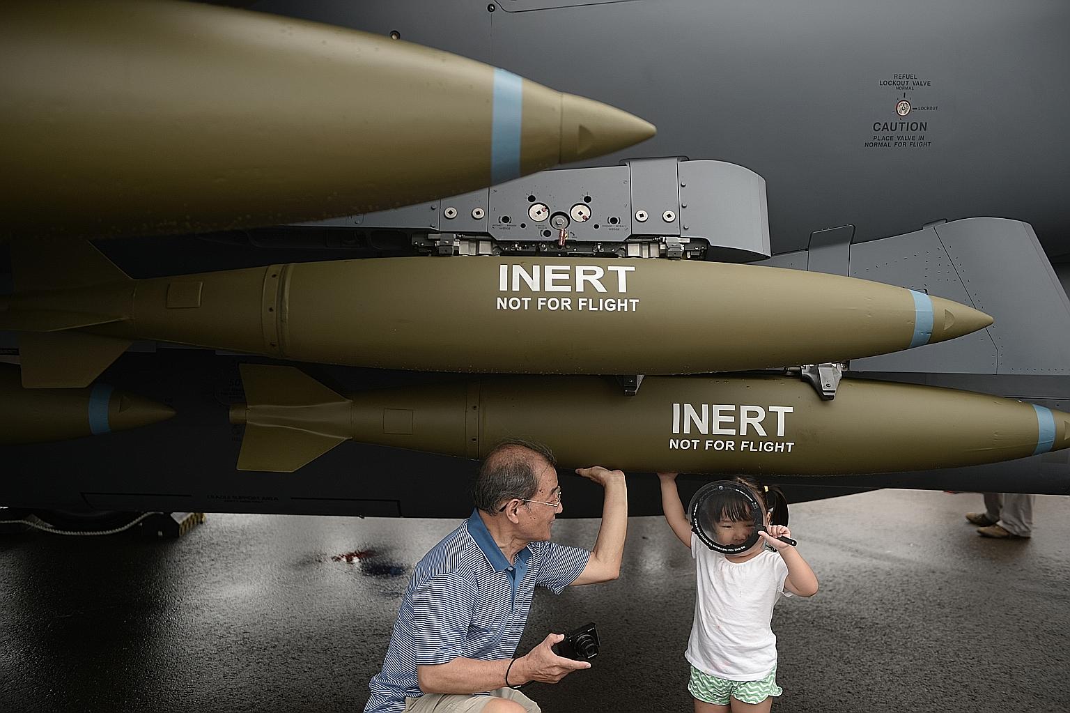 Zhang Yuehan, three, and grandfather Zhang Xiaoyi, 74, getting a feel of the RSAF F-15SG fighter plane. Visitors to the air show got to view more than 40 aircraft from the business, military and commercial sectors.
