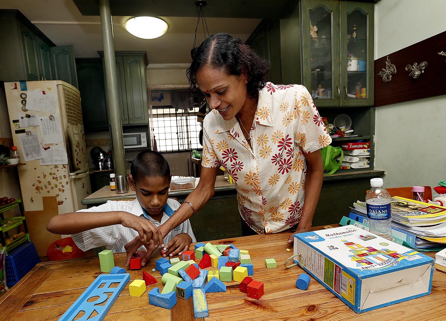 Madam Jayamalini with her second son, 11-year-old Immanuel, who was diagnosed with global developmental delay at birth and requires frequent hospital visits. The single parent has three sons, two of whom have special needs.
