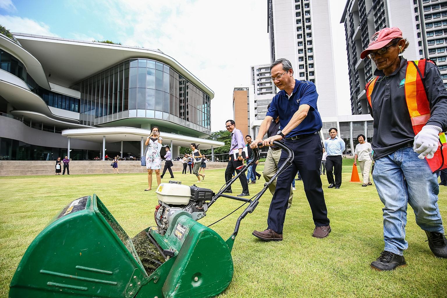 Mr Sam Tan trying out landscaping equipment at NUS University Town yesterday. He said employers can adopt a structured and targeted approach to provide more training and raise the skills of their workers.