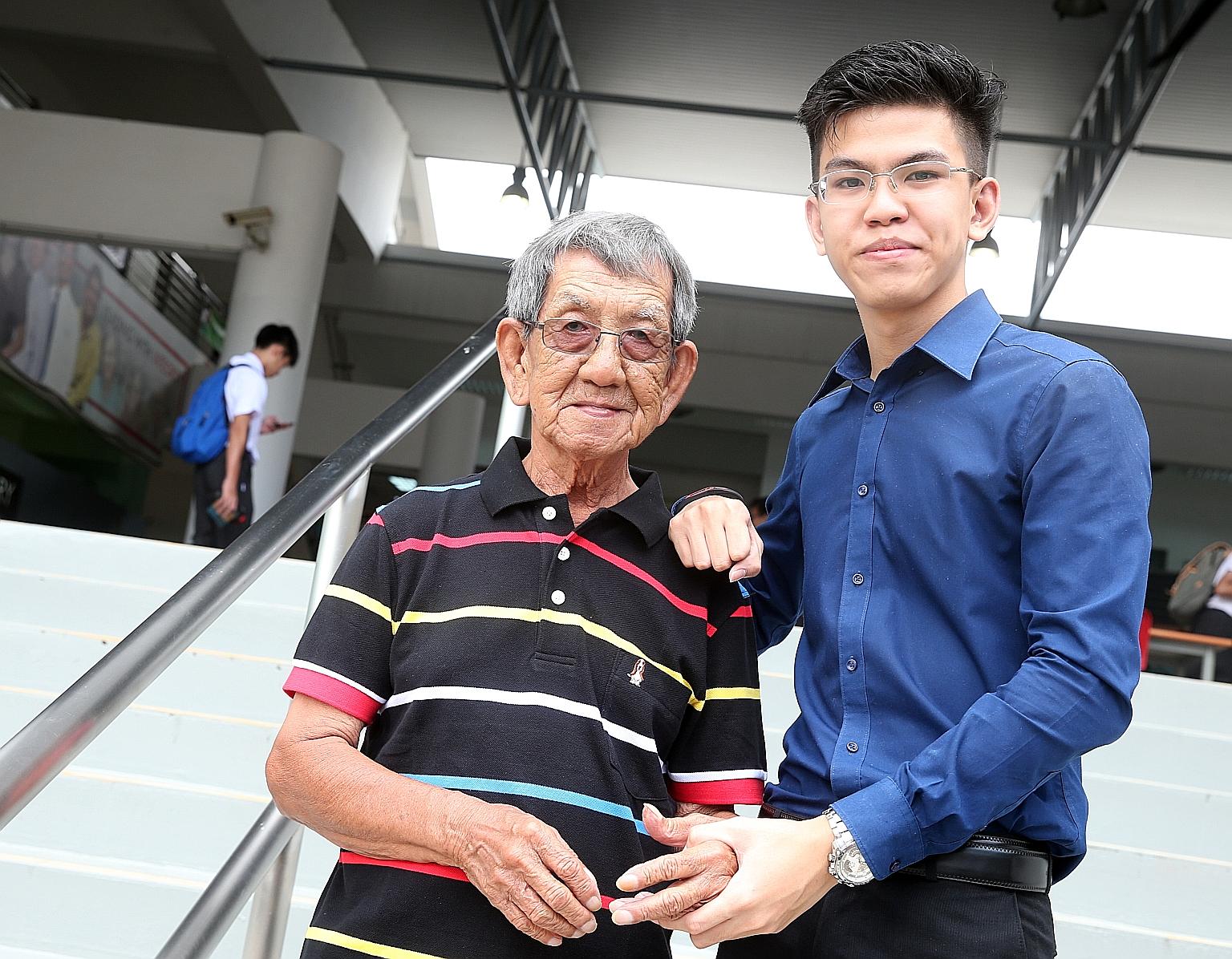Richmond, 18, with his grandfather Tan Khoon Seng, 78, who holds a cleaning job and is the sole breadwinner of the family.