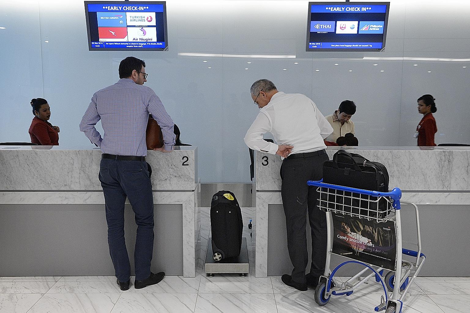 An airport staff member helping a passenger to get a queue number at the early check-in lounge at Changi Airport Terminal 1 yesterday. Passengers at the early check-in lounge at Changi Airport Terminal 1 yesterday. Early check-in counters at T2 and T