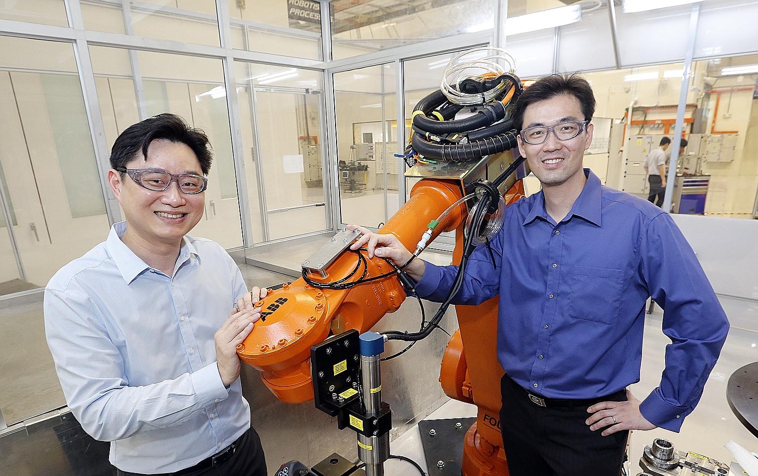 ARTC's Mr Ooi (left) and Sankei Eagle's Mr Siew with a manufacturing robot. Sankei Eagle worked with ARTC and aerospace firms to build a prototype to automate the masking process in application of coatings.