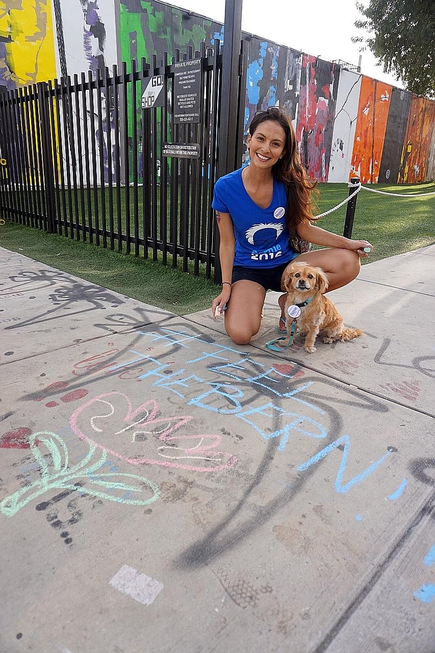 Actress Candice Loper Marisol, 33, chalking the pavement in support of Mr Bernie Sanders. She said she is tired of "corporate welfare that is going to big banks and companies".