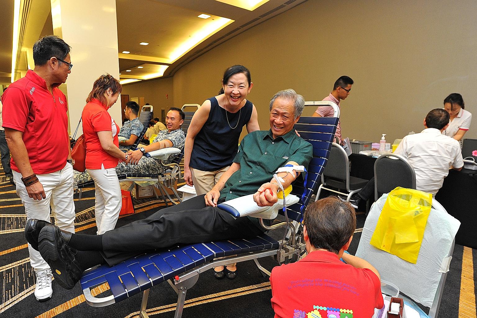 Dr Ng donating blood, with his wife, Professor Ivy Ng, standing by his side. Dr Ng was among the close to 100 people who participated yesterday in the inaugural Drops of Life blood drive by LoveSingapore at Suntec Singapore Convention and Exhibition