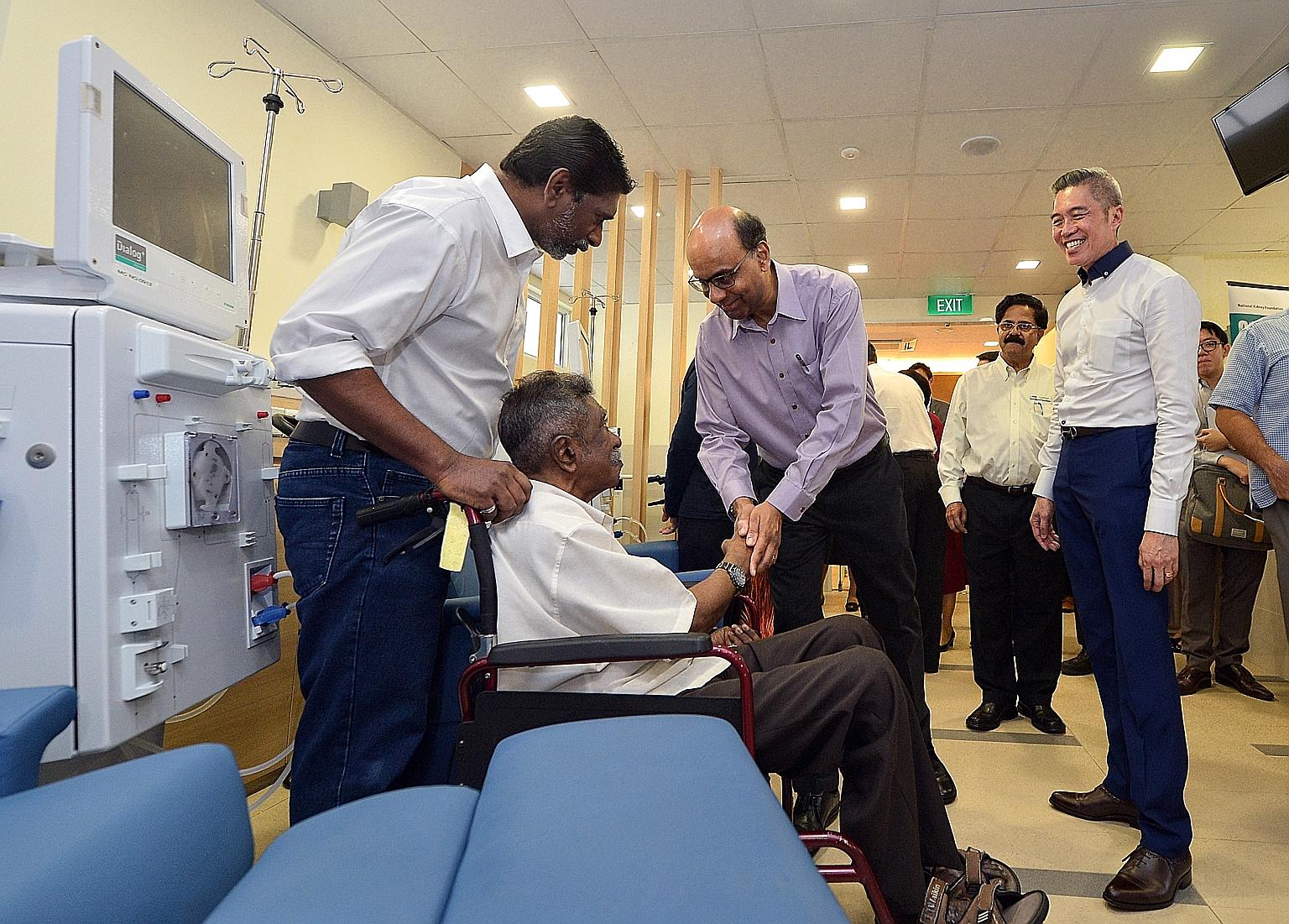 Deputy Prime Minister Tharman Shanmugaratnam greeting patient Sheik Adbul Kadir yesterday at the new dialysis centre in Jurong West. With Mr Tharman is Dr Mooppil Nandakumar (second from right), NKF's director of medical services, and NKF chief execu