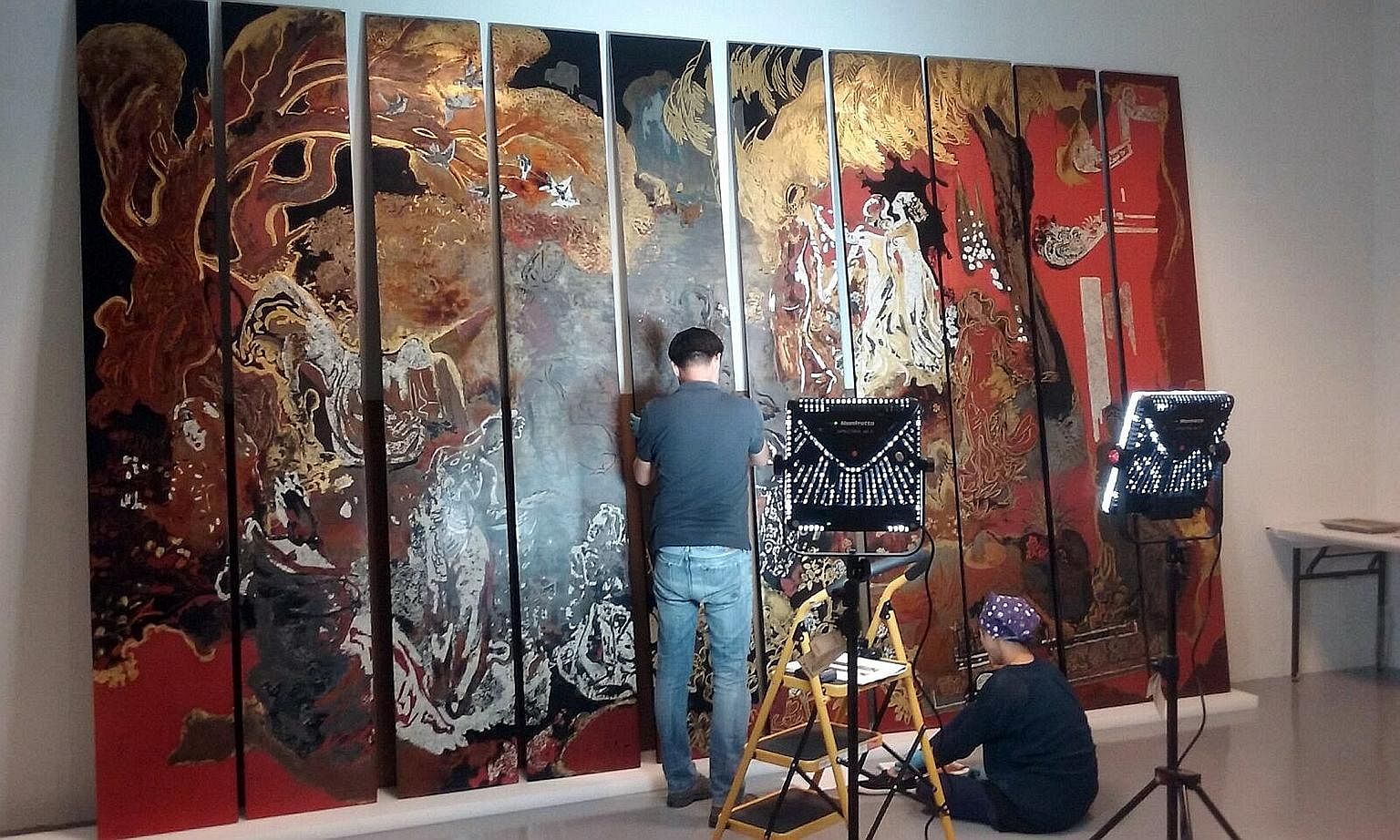 Conservators checking Nguyen Gia Tri's The Fairies (above), one of the works in Reframing Modernism (below), a new exhibition at the National Gallery Singapore.
