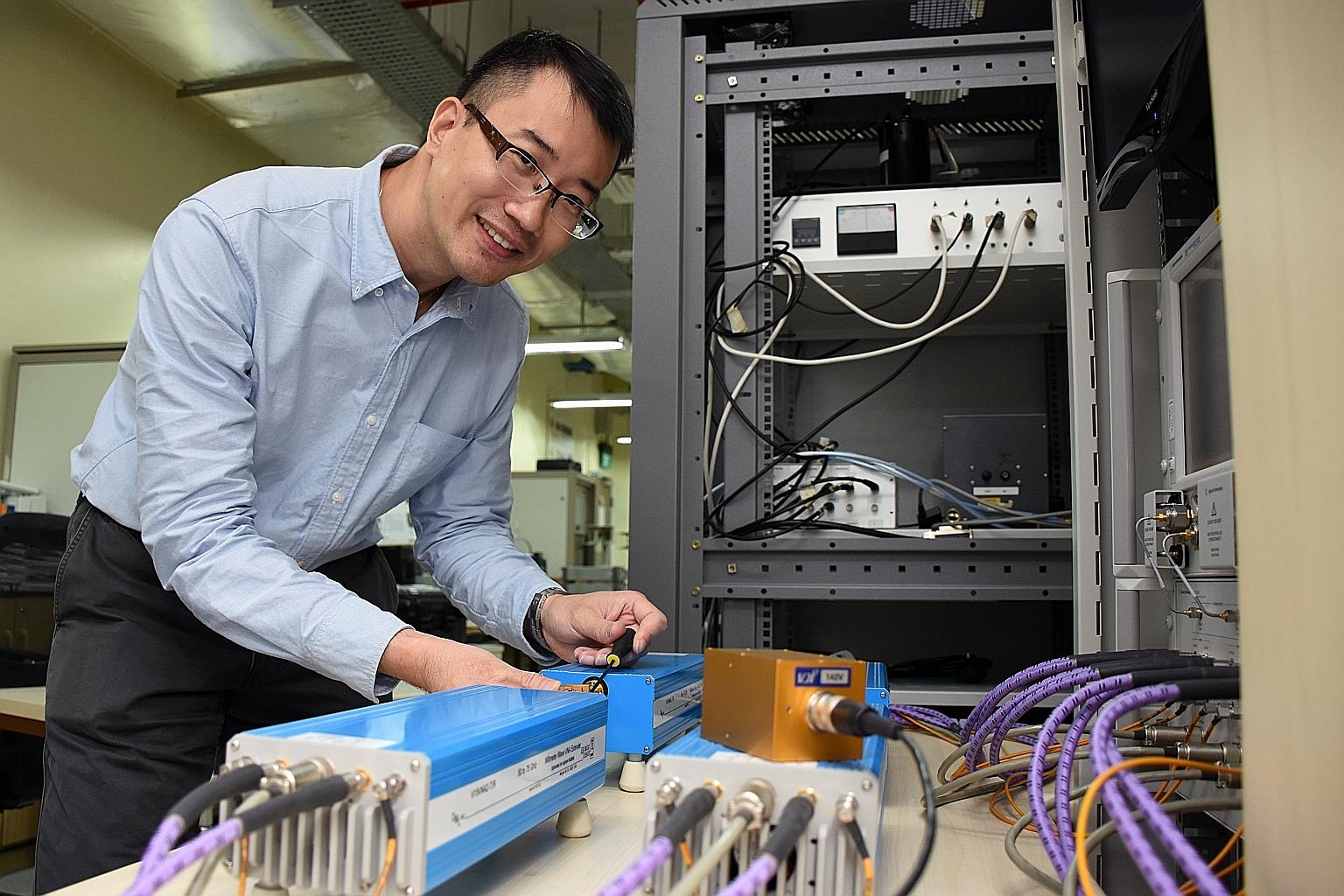 Dr Meng with a network analyser which helps to measure the parameters of radio frequency and microwave components