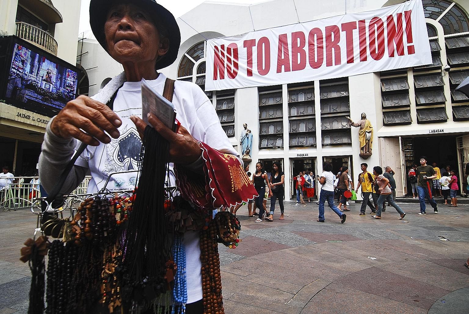 An anti-abortion sign on the wall of the Minor Basilica of the Black Nazarene in Quiapo, Manila. Vendors outside the church sell a dizzying range of goods, including the banned anti-ulcer drug Cytotec, known to induce miscarriage. That the "abortion 