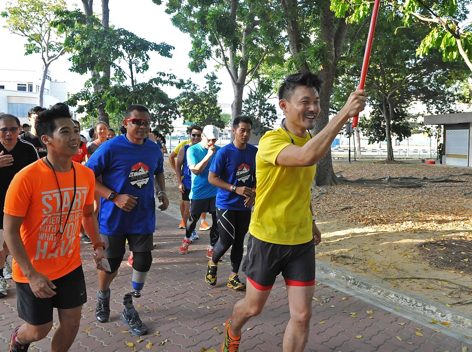 Mr Baey (in yellow) , the Parliamentary Secretary for the Ministry of Culture, Community and Youth, running with a group that includes "Blade Runner" Mr Shariff, Miles for Good project leader Mr Leong (in orange) and other participants in Tampines Ec