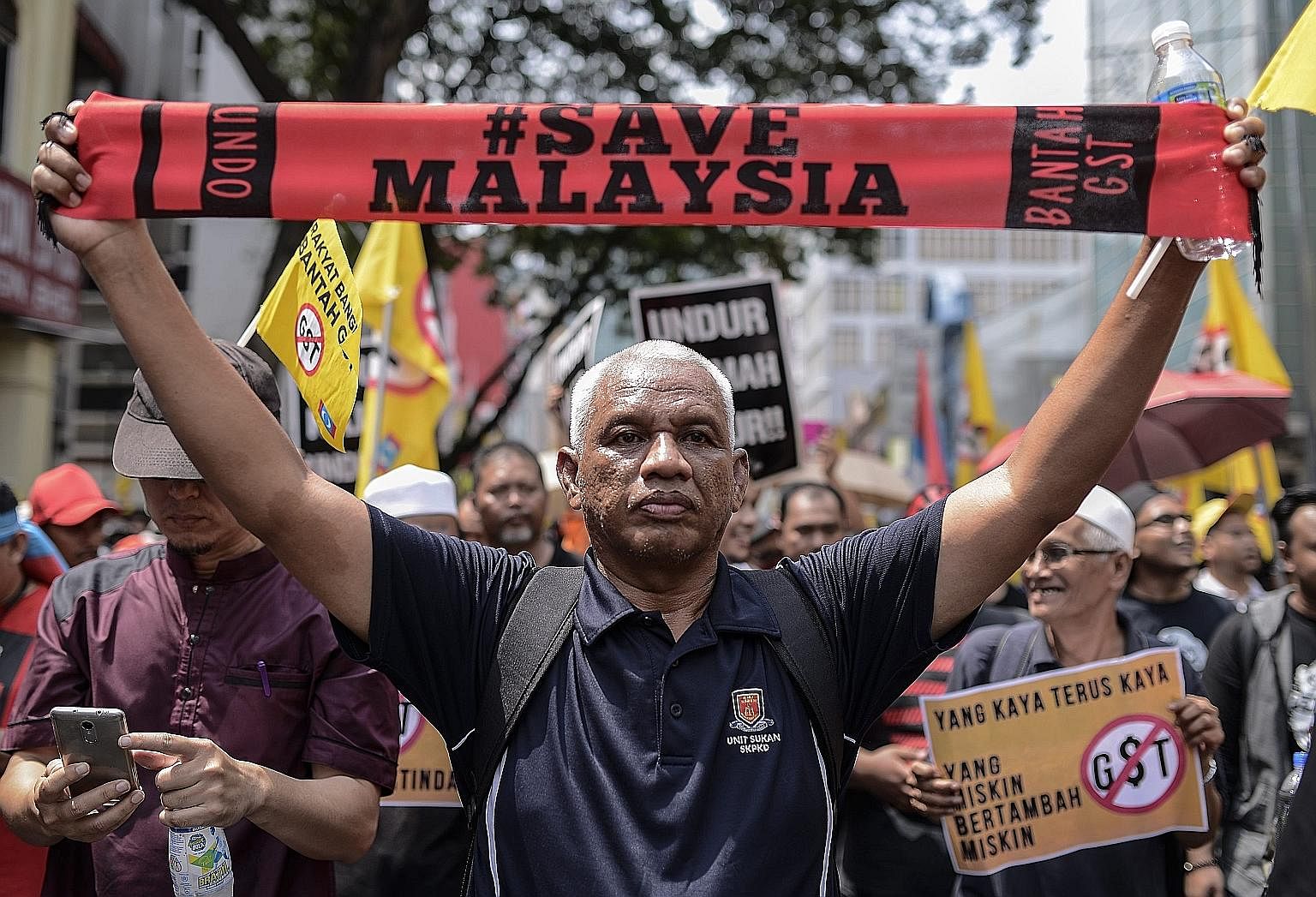 A demonstrator with a Save Malaysia banner during a rally in Kuala Lumpur on April 2. The rally called for the end of the Goods and Services Tax, implemented a year ago, as well as the release of jailed opposition leader Anwar Ibrahim and the resigna