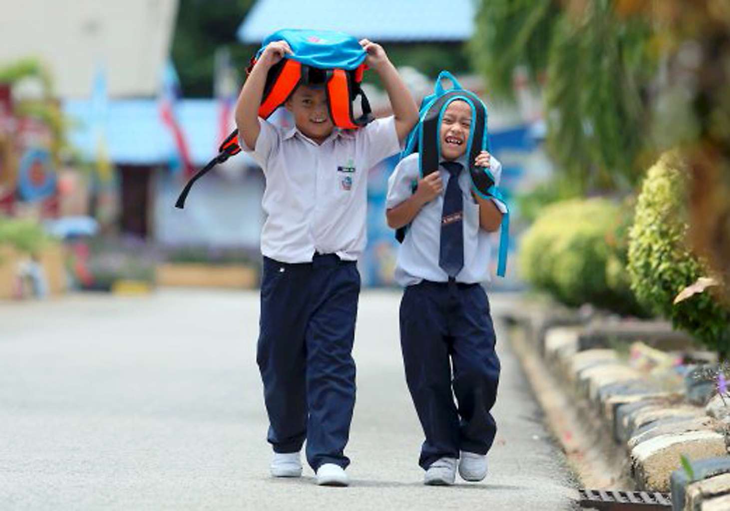 Students from a school in northern Malaysia sheltering themselves from the sun.