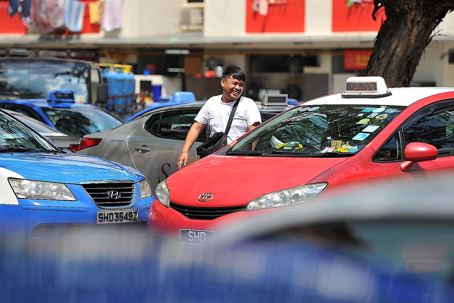 A Grab staff member trying to recruit taxi drivers to use the app outside the Bukit Merah View hawker centre, a popular spot for cabbies to take a break.