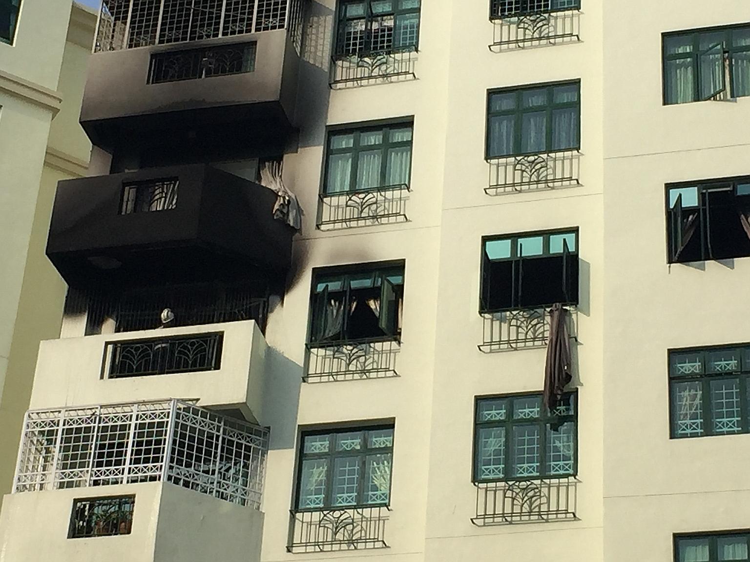 The smoke-blackened exterior of the condo unit at Hillview Green. One of the residents, Mr Timothy Ng, climbed down from the window of the seventh-floor unit to the floor below, after failing to open the main door. He went back up to open the door fr