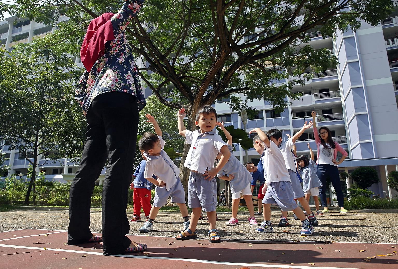 Tiny tots getting some stretching pointers from their teachers at PCF Sparkletots Preschool in Bedok North Road. Education experts say besides comparing prices when looking for a pre-school, parents may also want to observe the quality of interaction