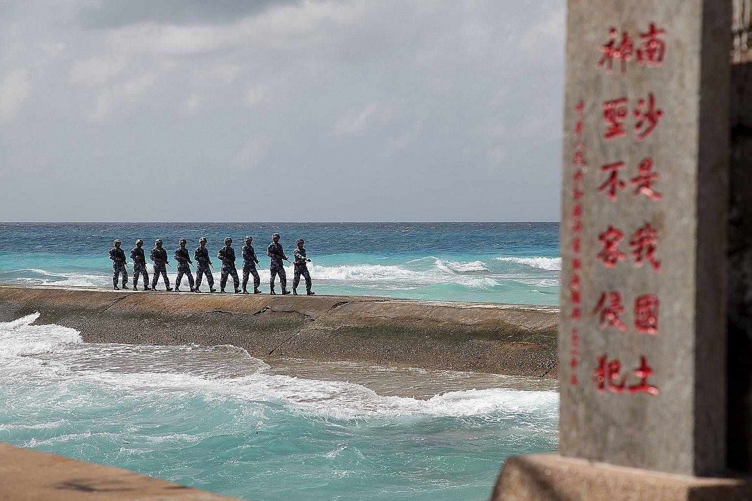 Chinese soldiers on the Spratly Islands, known in China as the Nansha Islands, earlier this year. The sign reads: "Nansha is our national land, sacred and inviolable". China's adventurism in the South China Sea has prompted a change in Australian pol