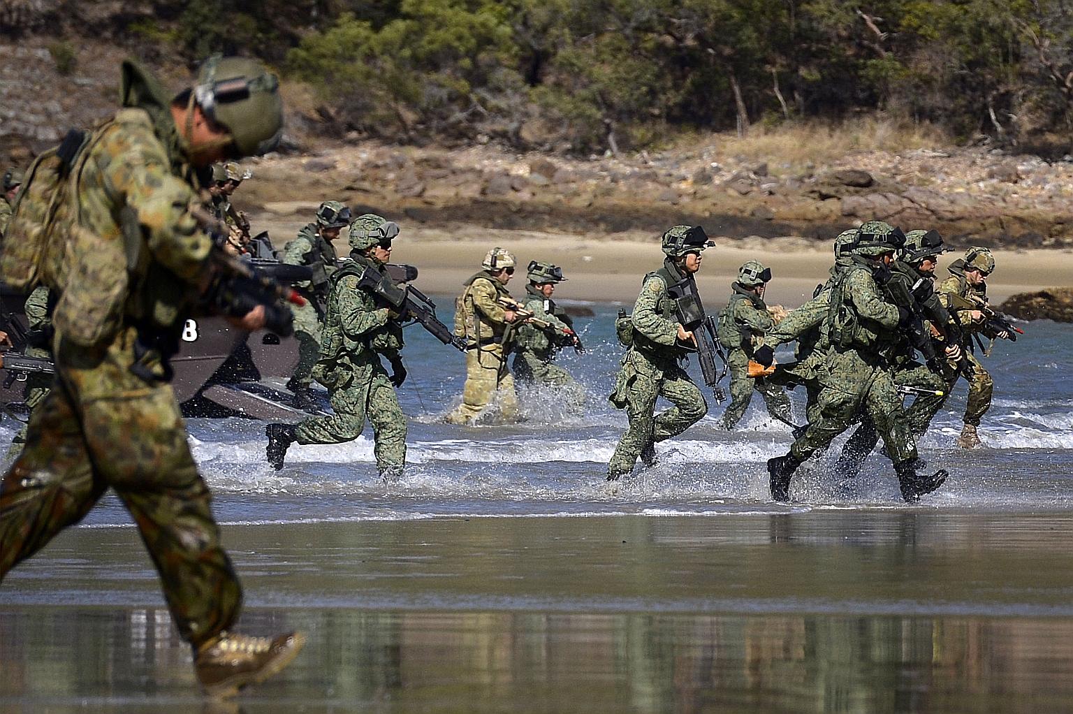 Soldiers from the SAF Guards battalion and the Australian Defence Force's 7th Australian Regiment carrying out a beach landing in the Shoalwater Bay Training Area in 2014, during a preview of Exercise Trident.