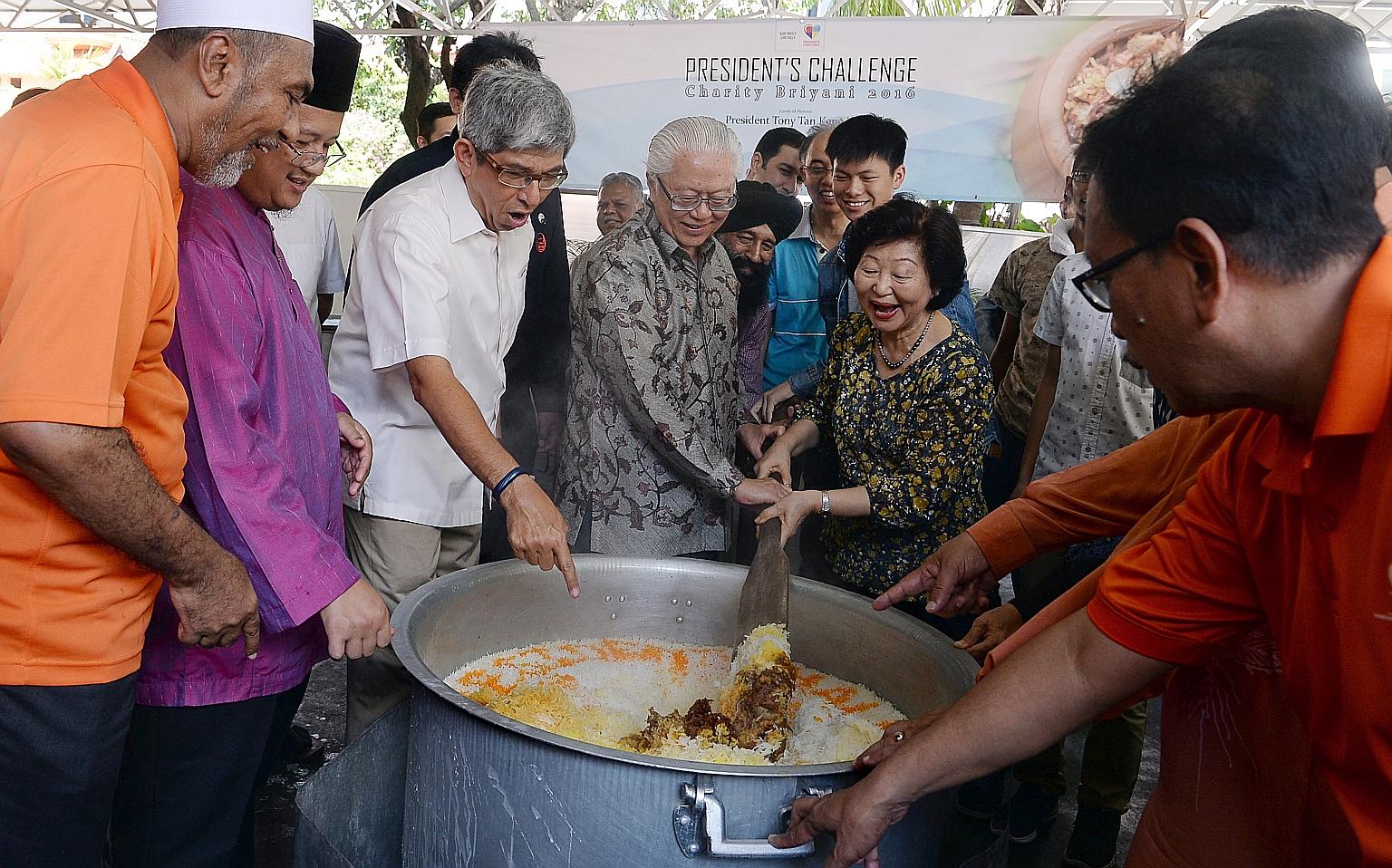Dr Tan and his wife Mary stirring a pot of briyani as (from left) Mr Alla'udin, Mufti Mohamed Fatris Bakaram and Dr Yaacob look on. All 69 mosques here sold coupons for the rice dish as part of The President's Challenge Charity Briyani. Organisers ai