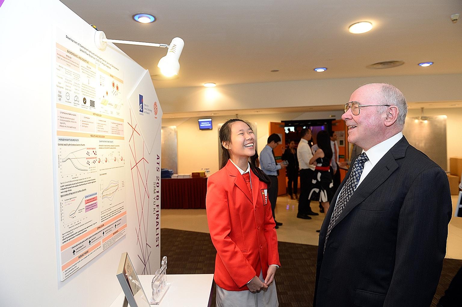 Yu Ki discussing her research project, a portable dengue fever diagnostic kit, with Professor Johann Deisenhofer, Nobel laureate and chief judge of the A*Star Talent Search Awards Committee.
