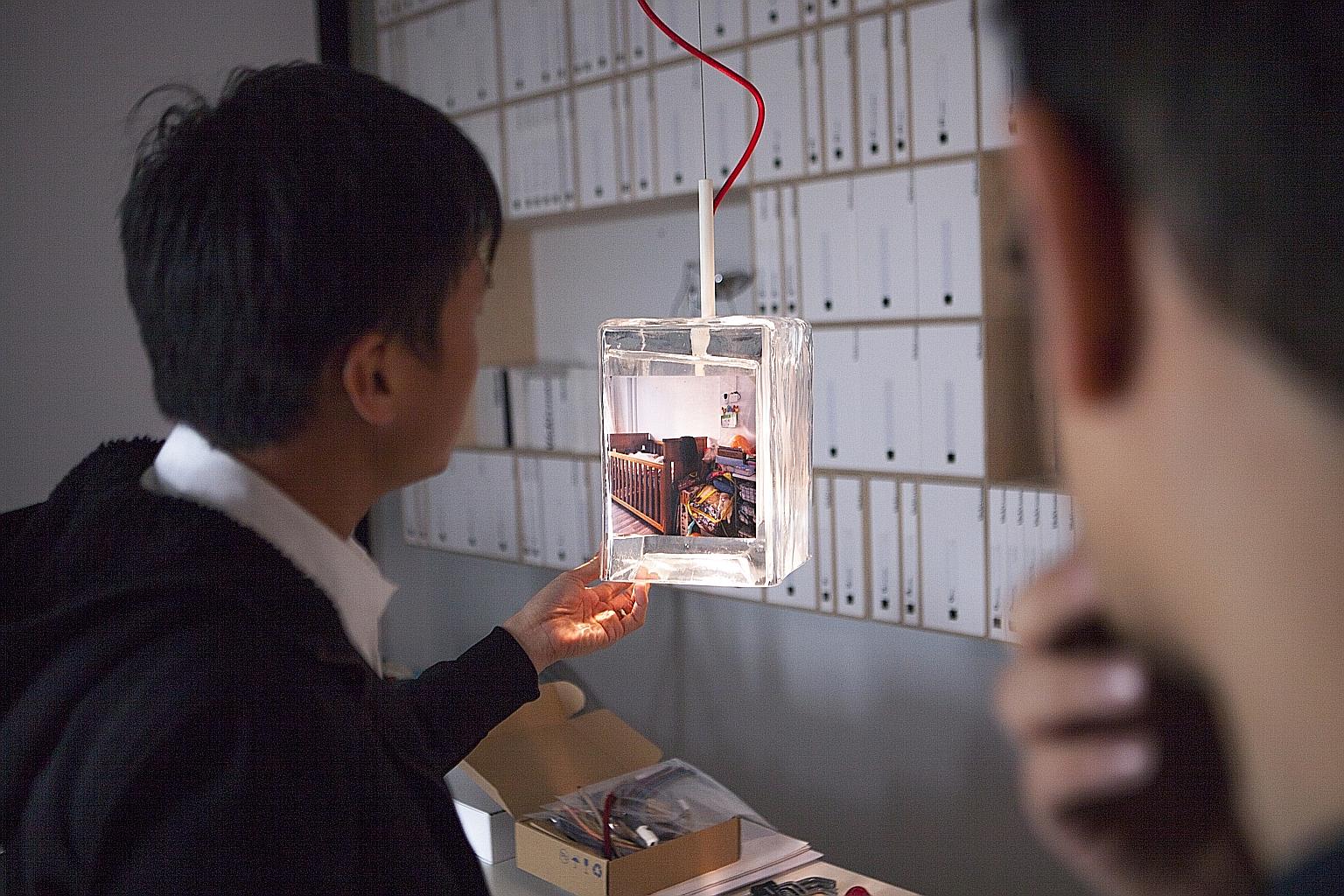The centrepiece of the Singapore Pavilion is a grid-like display of 81 customised glass lanterns, each featuring a model of an HDB building and three illuminated photographs of the homes of ordinary Singaporeans living in public housing.