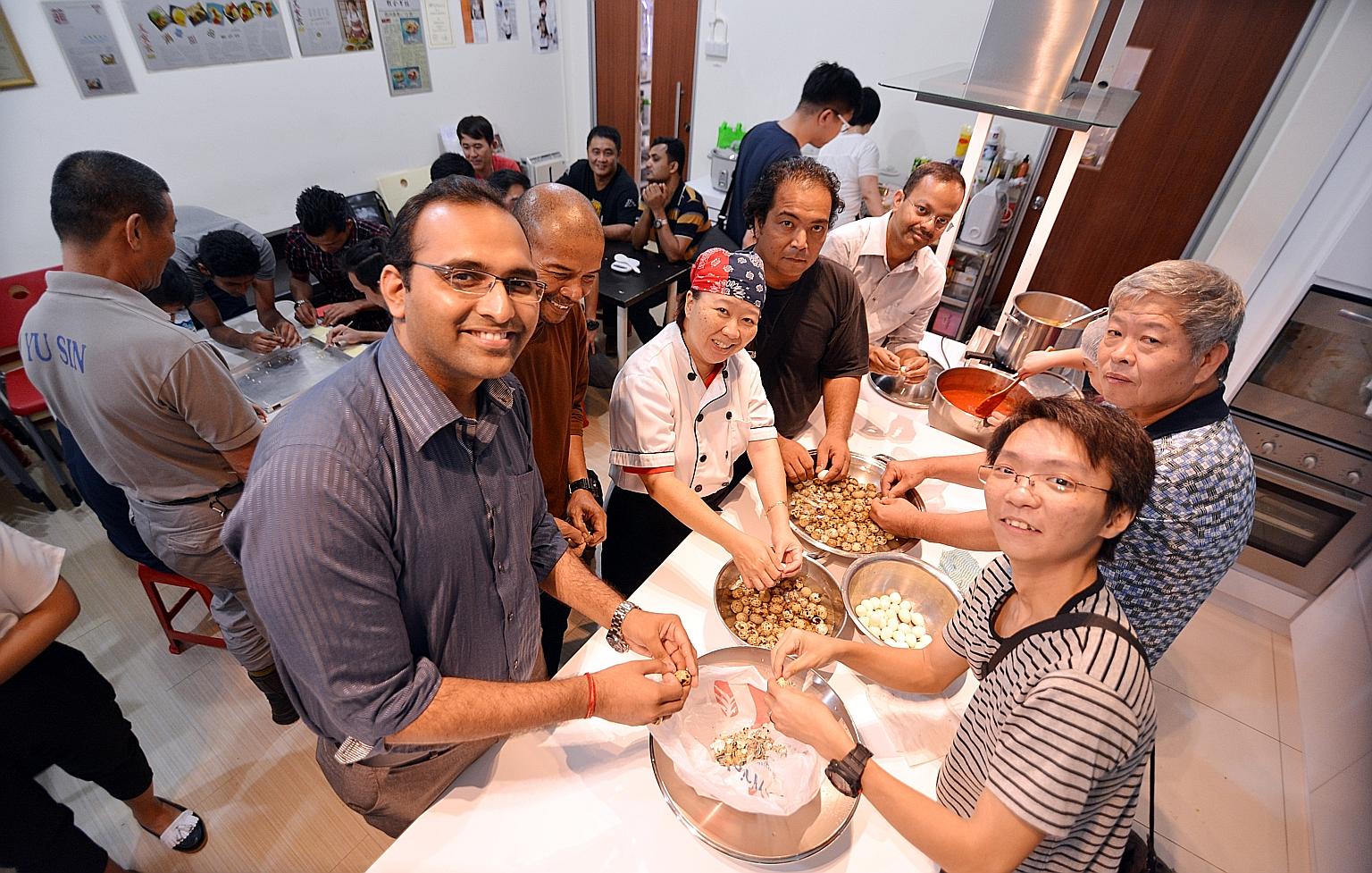 Mr Mathur (left) and some of the 22 other volunteer cooks join chef Geraldine Tan in preparing dinner for 70 children whose mothers are beneficiaries of local charity, Daughters of Tomorrow, which trains and coaches underprivileged women.