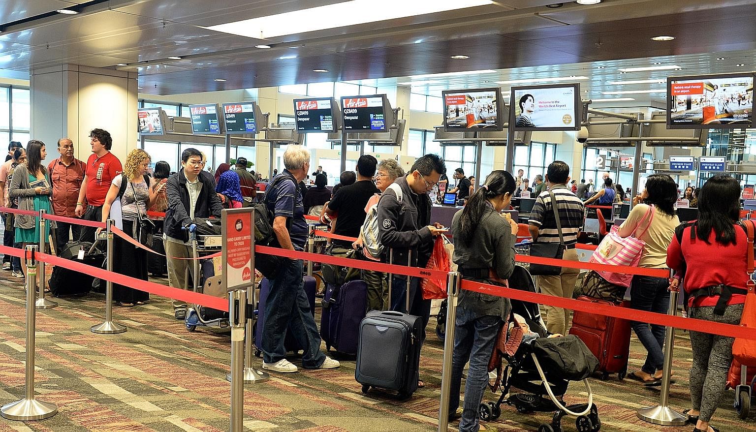 Travellers at the AirAsia check-in counter at Changi Airport Terminal 1. Mr Wilson, the chief executive of Scoot, says the new alliance among eight low-cost carriers is a strategic move against other airline groupings. Three of the biggest budget air