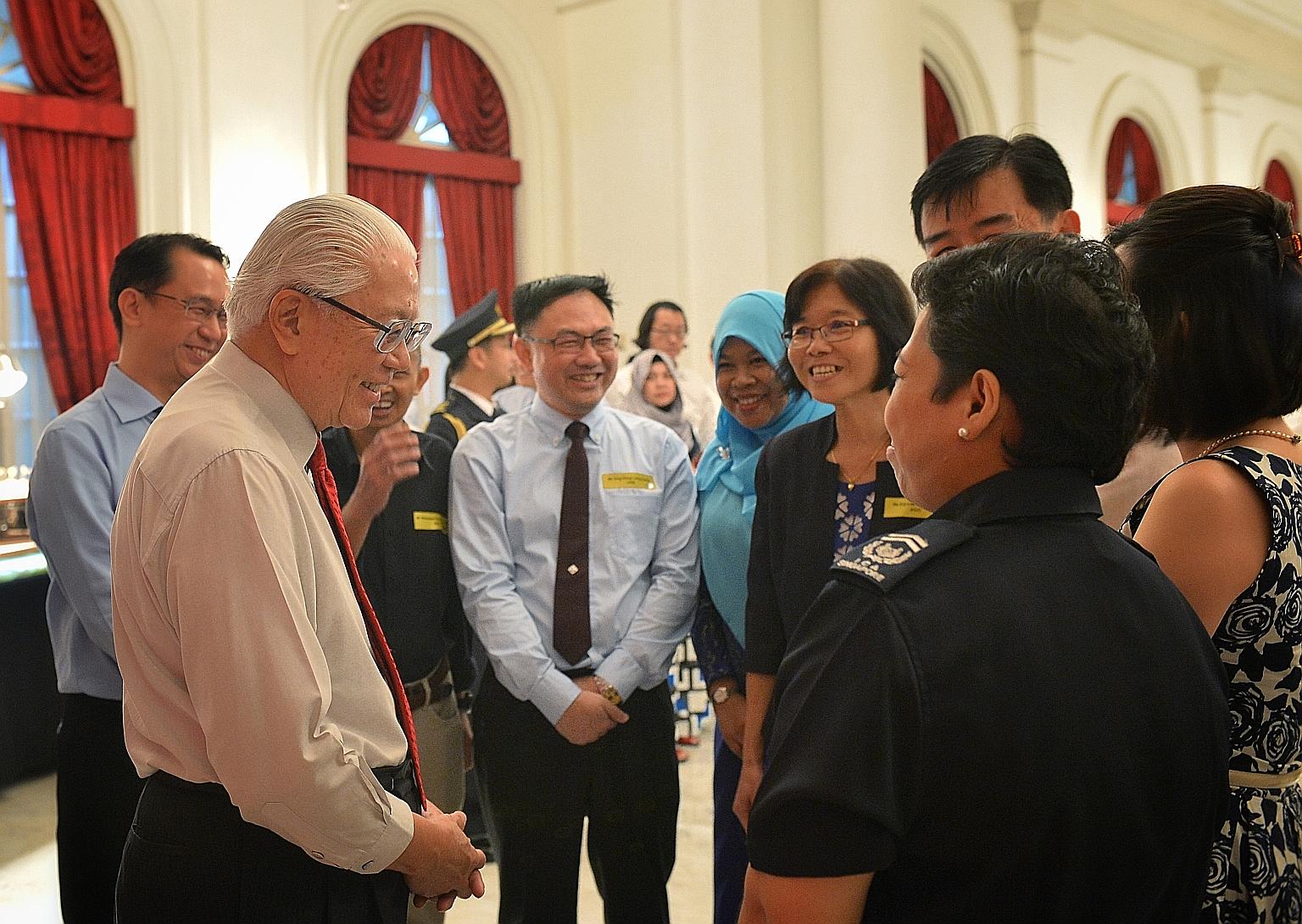 President Tony Tan Keng Yam speaking to civil servants, including Immigration and Checkpoints Authority Checkpoint Inspector (2) Zarina Zainee at an Istana reception yesterday evening. Some 500 public officers attended this year's reception, hosted b