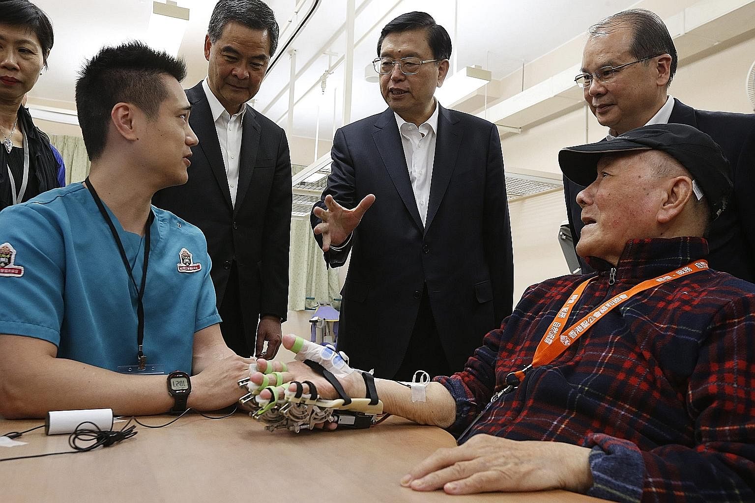 Mr Zhang (centre) speaking to a care provider at an aged care complex in Hong Kong yesterday. During his visit to the city, he attended 18 events, including meeting pan-democratic politicians.