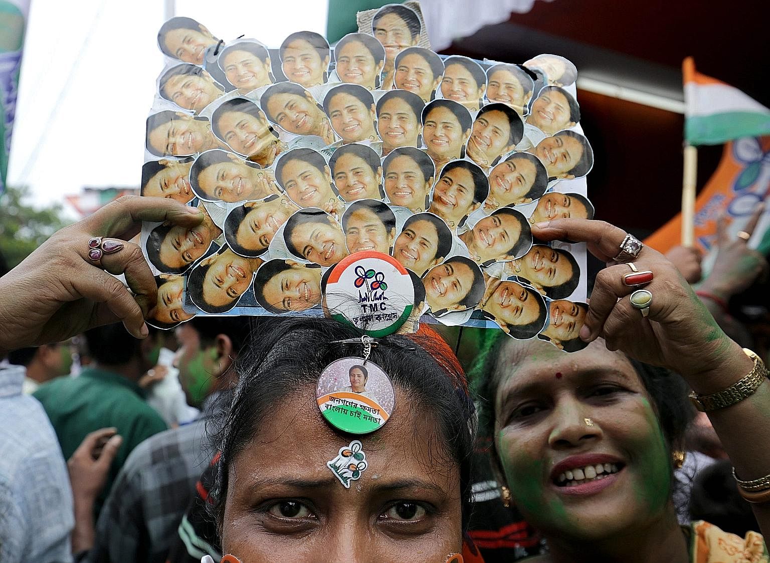 A Trinamool Congress party supporter wears a crown made out of Chief Minister Mamata Banerjee's photos during celebrations after she won an absolute majority in the West Bengal Assembly election in Kolkata.