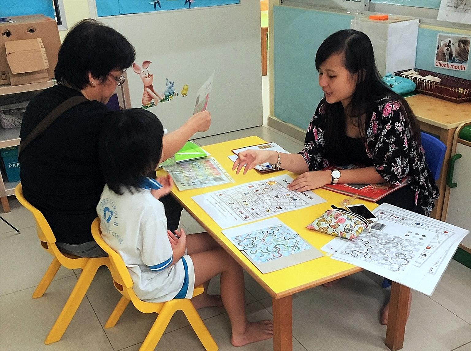 A volunteer helping a parent and child at a Transition to P1 playshop organised under the Circle of Care scheme, which has led to higher rates of school attendance and gains in learning for at-risk children at the two centres in Leng Kee and Admiralt