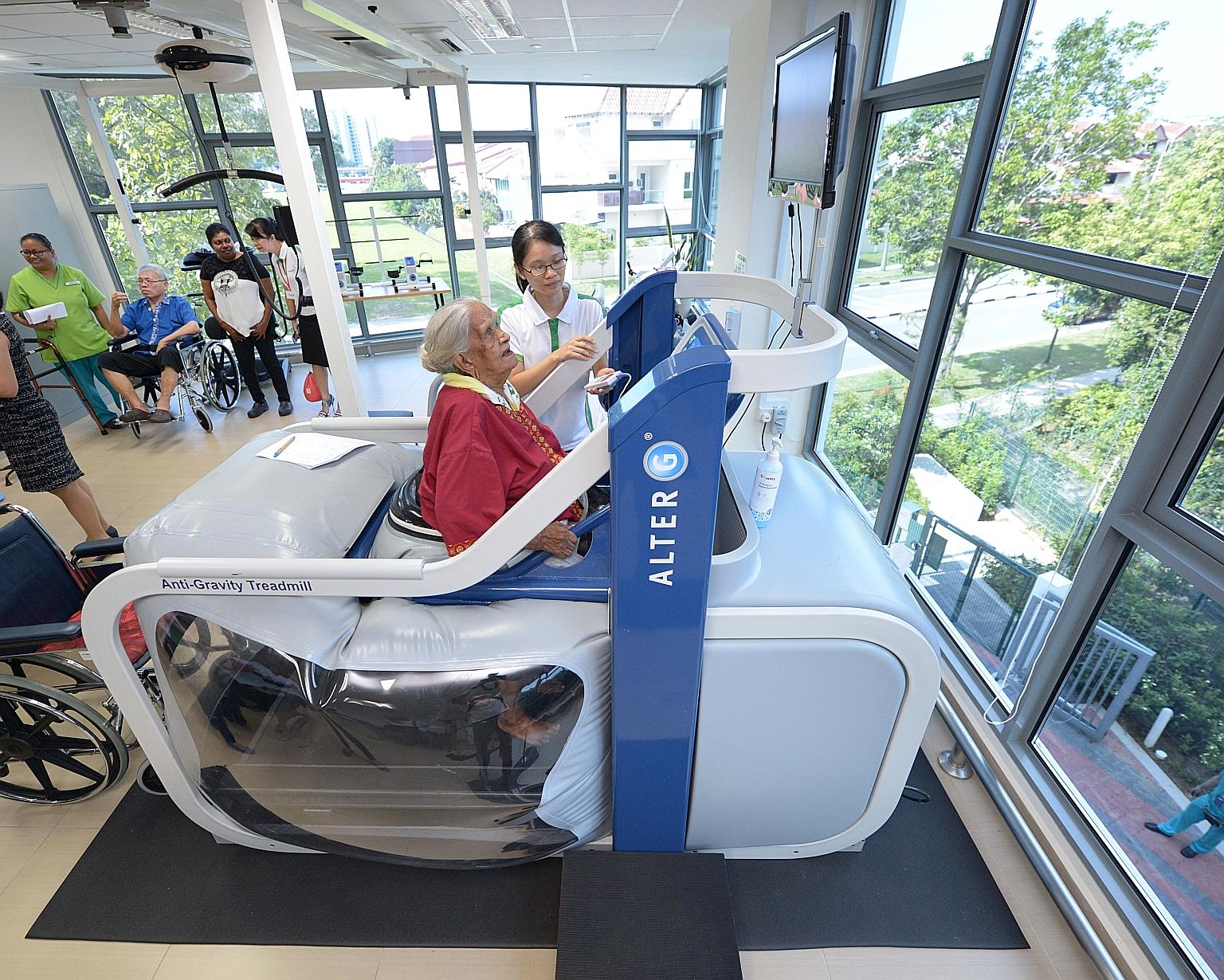 Madam Karumaya Kaiyammal, who is 101 years old, exercising on the anti-gravity treadmill machine under the supervision of physiotherapist Lee Pei Pei at the NTUC Health nursing home in Jurong West yesterday. Based on space technology that uses air pr