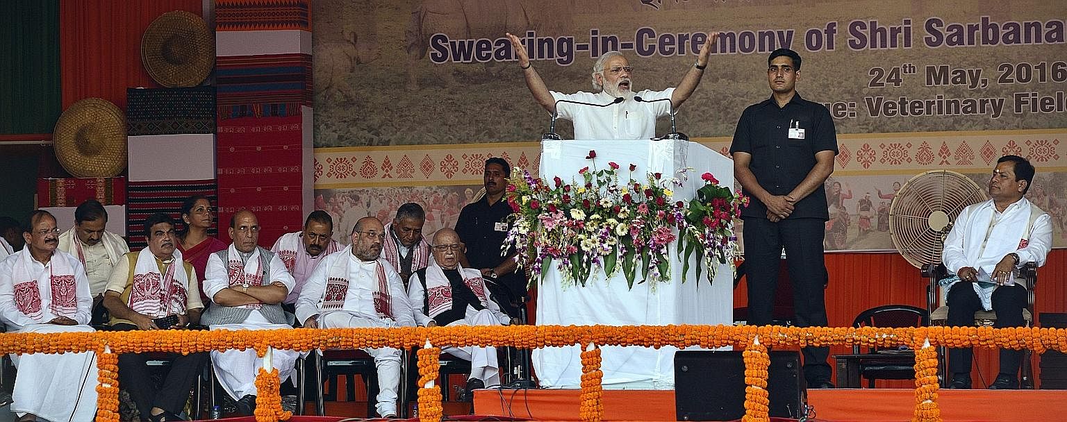 Mr Modi delivering a speech at the swearing-in ceremony for 10 ministers and Assam's new Chief Minister Sarbananda Sonowal (right) in Guwahati, Assam, on Tuesday.