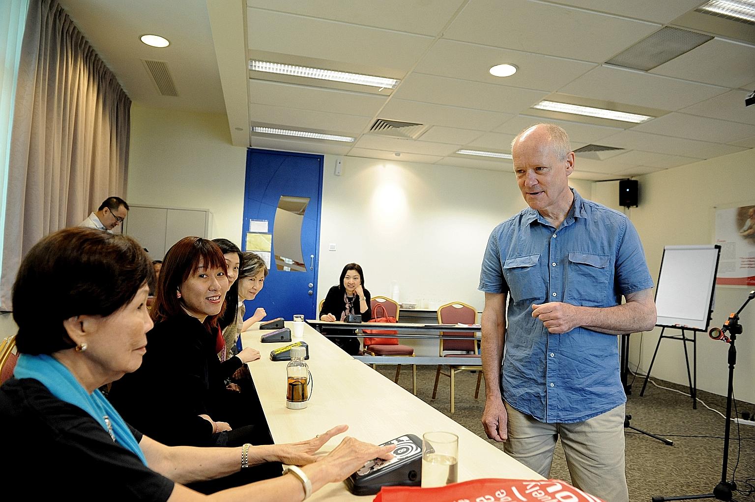 Mr Swingler conducting a train-the-trainers programme as Mrs Carmee Lim (foreground, wearing a blue scarf), operates a wireless switch to make music with the Soundbeam set.