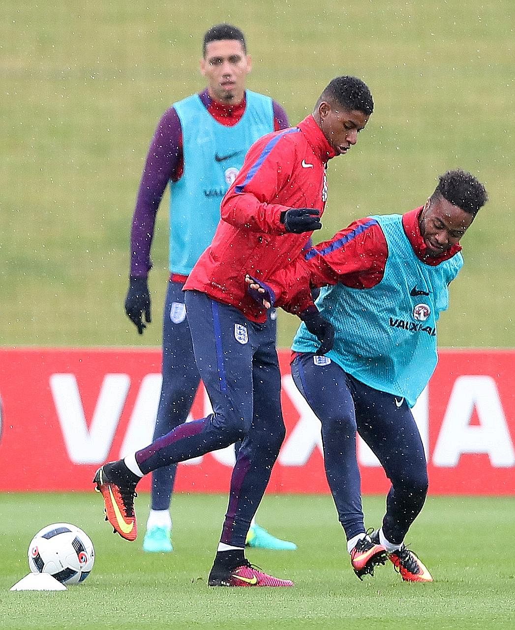 Marcus Rashford (centre) keeping the ball away from Raheem Sterling during England's training session as Chris Smalling watches on.