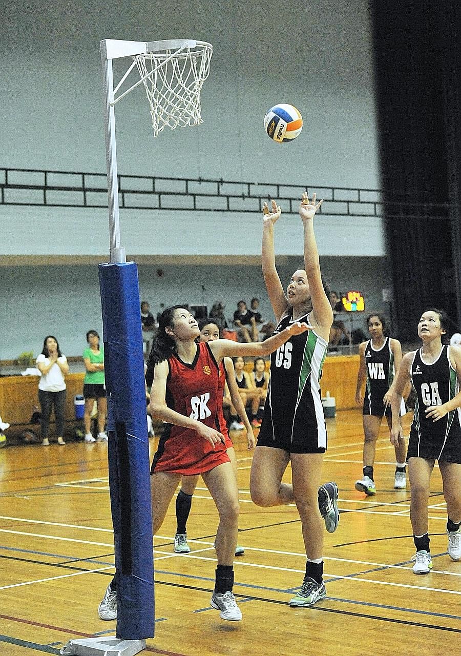 Raffles Institution goal shooter Isabelle Belanger (second from left) shoots as Hwa Chong Institution goal keeper Low Yixuan (left) defends at the Jurong East Sports Hall. Isabelle scored a game-high 50 points, single-handedly outscoring HCI.