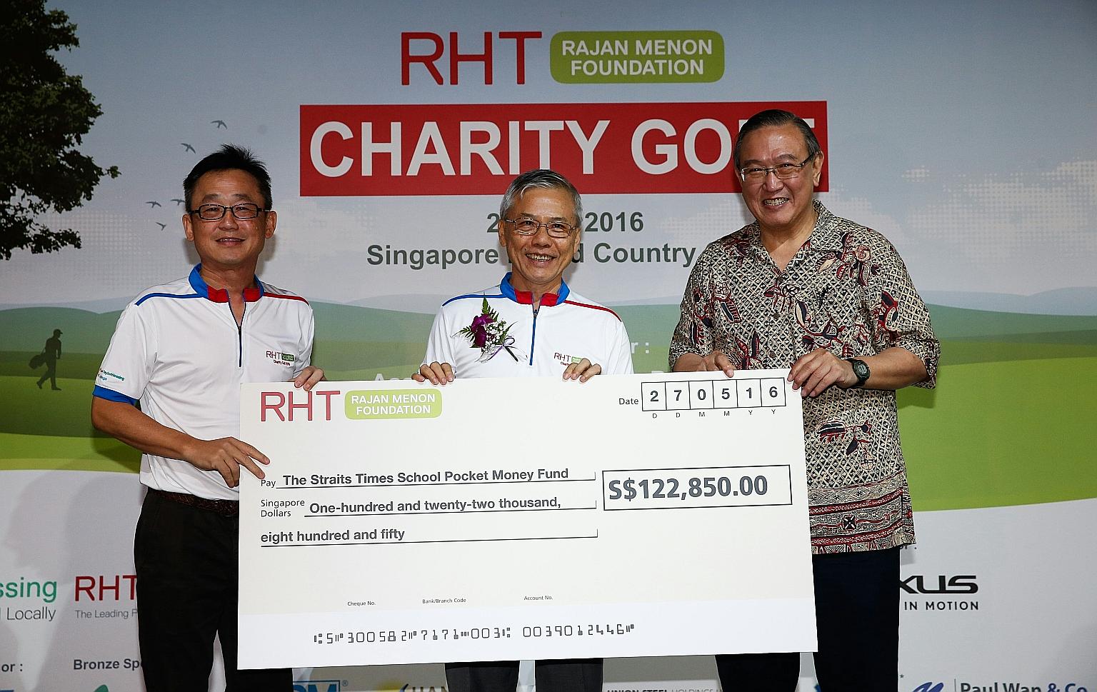 The Straits Times School Pocket Money Fund (SPMF) board trustee, Mr Gerard Ee (right), received a cheque for $122,850 on behalf of the fund from RHT Rajan Menon Foundation chairman Tan Chong Huat (at left) and the foundation's patron, Associate Profe