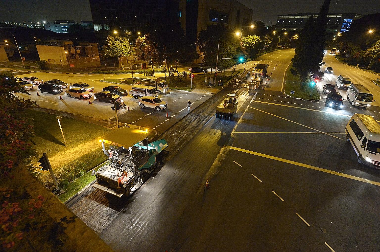 Workers resurfacing the affected section of Jalan Boon Lay last night. It was scheduled to be completed by 2am.