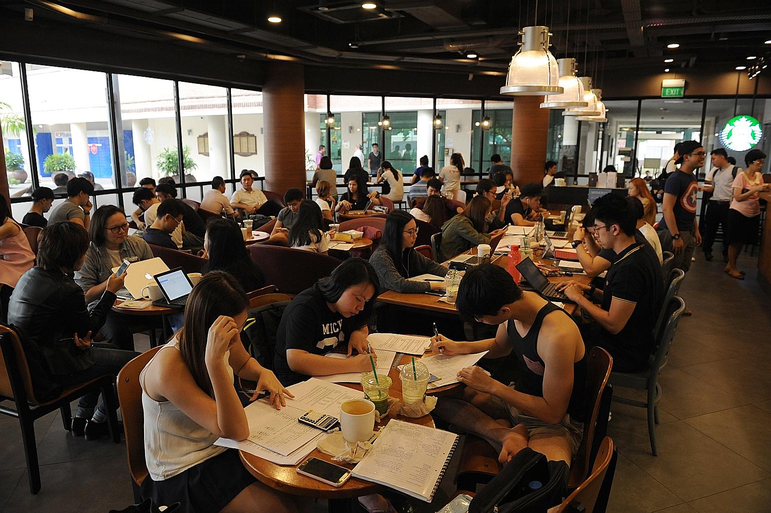 Students at the Starbucks cafe at Bishan Community Club on a weekday afternoon. Some eateries try subtle hints such as clearing the empty dishes or putting up signs discouraging seat-hogging during peak periods. A few have added more tables.
