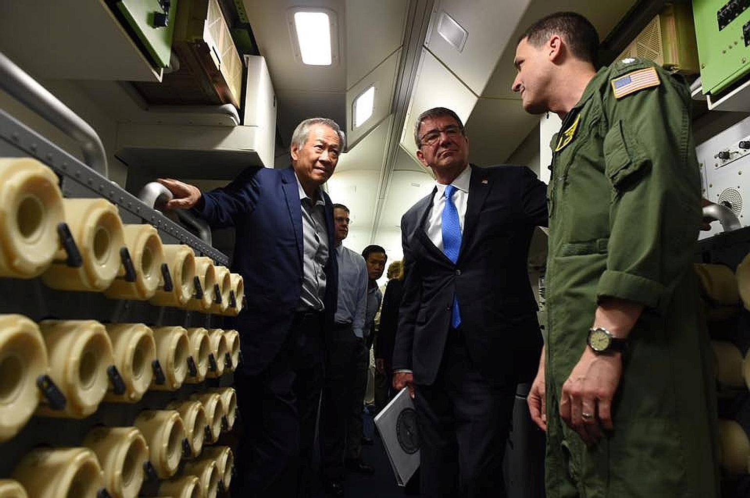 Dr Ng (left) and Dr Carter (centre) on board the US Navy P-8 Poseidon surveillance aircraft yesterday. The plane, which is deployed to Singapore, flew for an hour over the Strait of Malacca. Dr Ng said the flight underscored the shared belief in the 