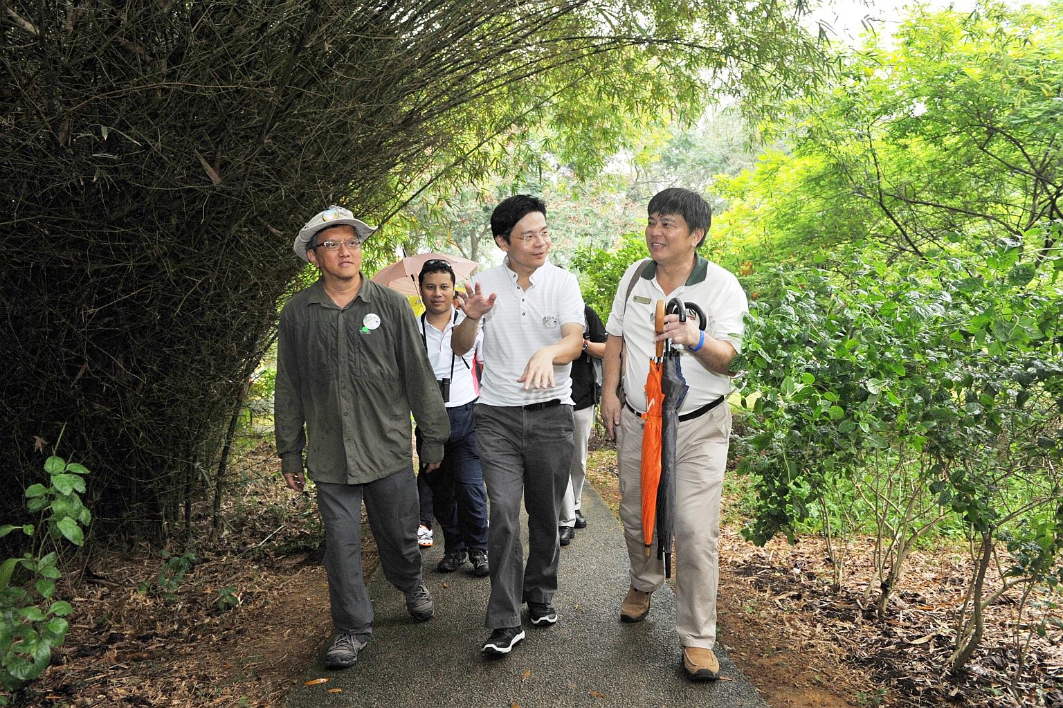 Mr Lawrence Wong (centre) with (from far left) ButterflyCircle founder Khew Sin Khoon, Senior Minister of State for National Development Desmond Lee (behind) and NParks' director for Pulau Ubin Robert Teo Chee Hin on a butterfly trail on Pulau Ubin.