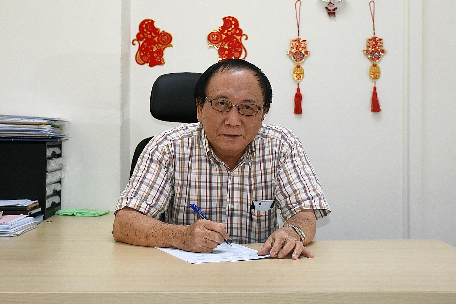 Mr Aik (left) helped Yang Yin fill in an application form for PR.