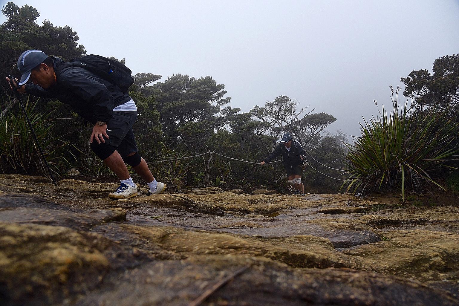 Couple Tonny Phuay and Joyce Lim making their way up the gruelling trail to Laban Rata, which is the rest point before the climb to the summit of Mount Kinabalu. Their daughter, Chantal, who was ahead of them, is a survivor of last year's earthquake.