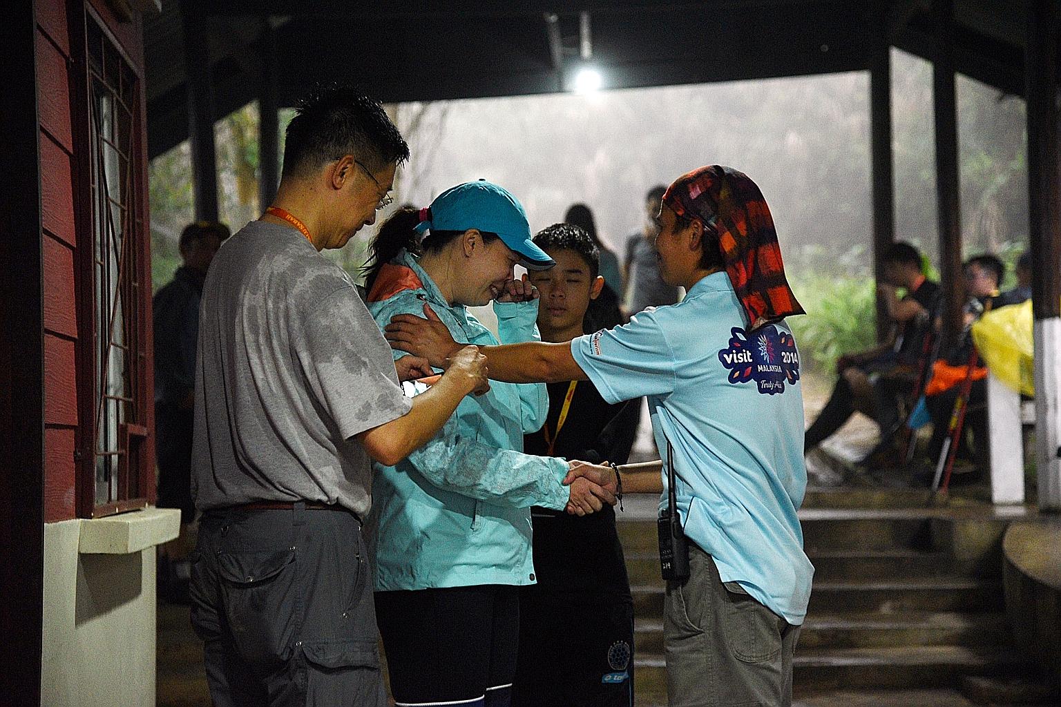 Mr John Quok and wife Mae Molina thanking 45-year-old mountain guide Ehing Sakumbang (right), who saved their son Elliot (background) during last year's earthquake. Elliot and his parents were among those who returned to trek Mount Kinabalu this year